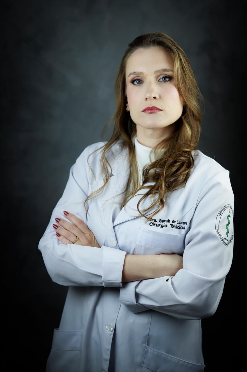 Dra. Sarah de jaleco, braços cruzados